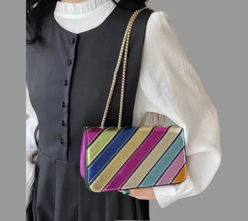 Metallic Colorburst Handbag with multicolored design and metallic finish, worn by a model in a black dress.