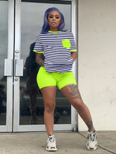 Trendy striped top and neon biker shorts set for women.