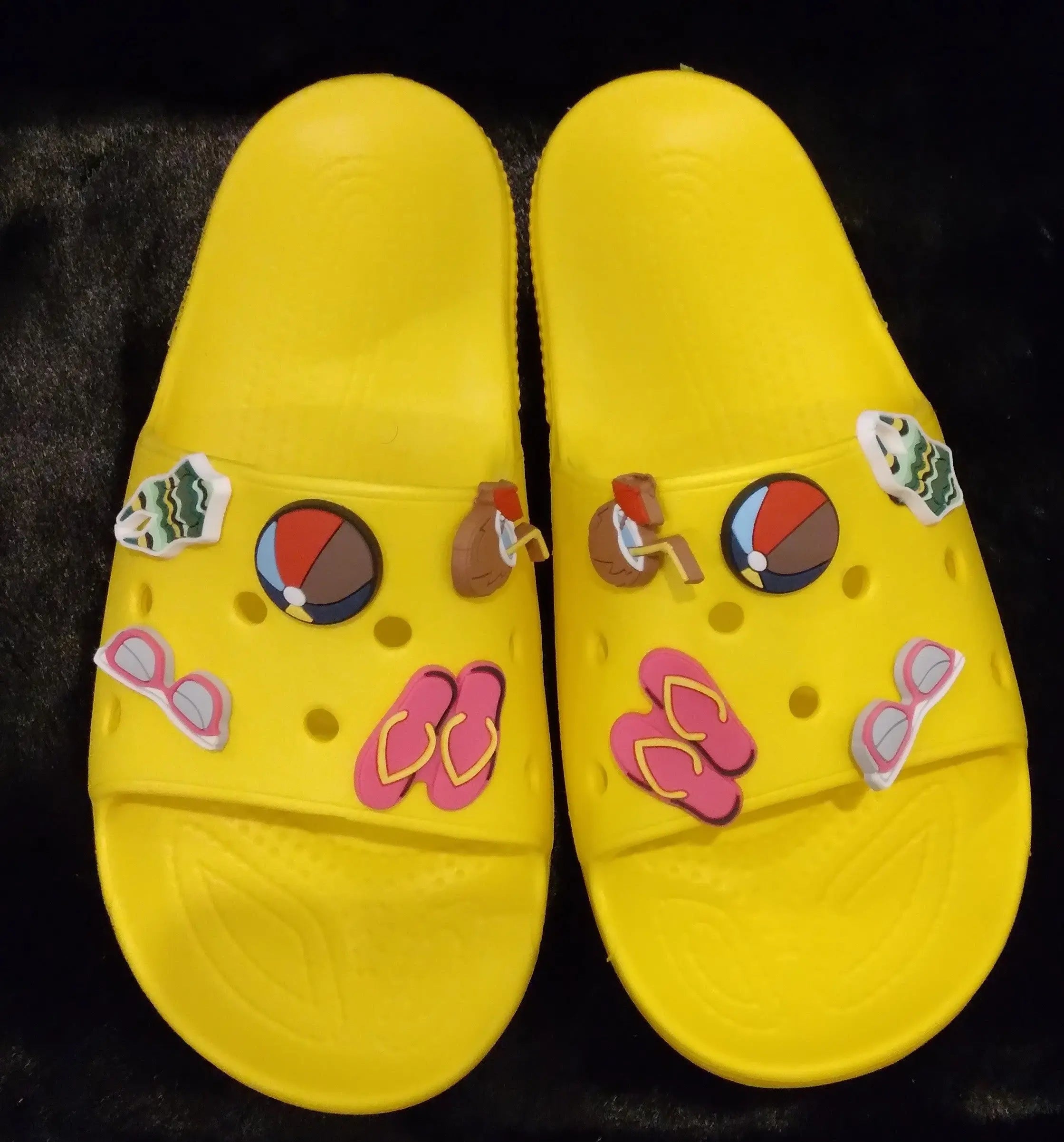 Yellow sporty chill slides with decorative charms.