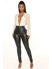 Woman wearing high-rise faux leather jean pants with slim fit and rear pockets.