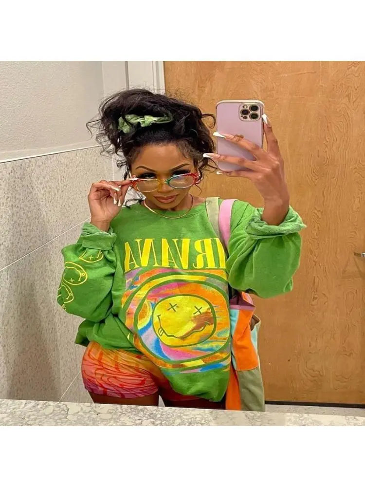 Iconic Influencer Sweater with bright Nirvana graphic worn in mirror selfie.