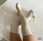 Thigh high beige knitted boots with thick soles for women.