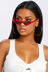 Woman wearing red Wildcat Sunglasses with hoop earrings.