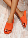 Vibrant colored lightweight open toe sun slides on wooden floor.