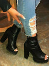 Women's black trendy open front booties with high heels.